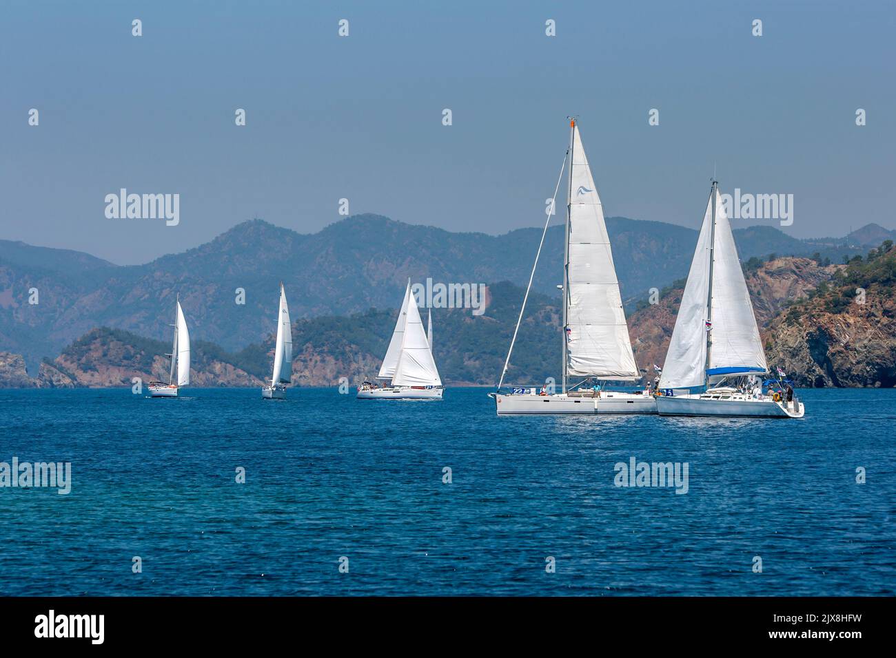 A fleet of sailing yachts  maneuver in the Aegean Sea  off the Turquoise coast of Turkey near the port city of Fethiye. Stock Photo