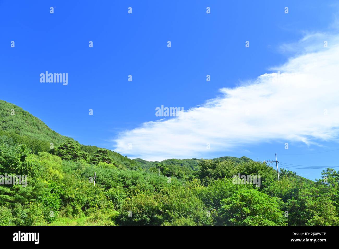 There is a blue mountain and white clouds cross the clear sky Stock Photo
