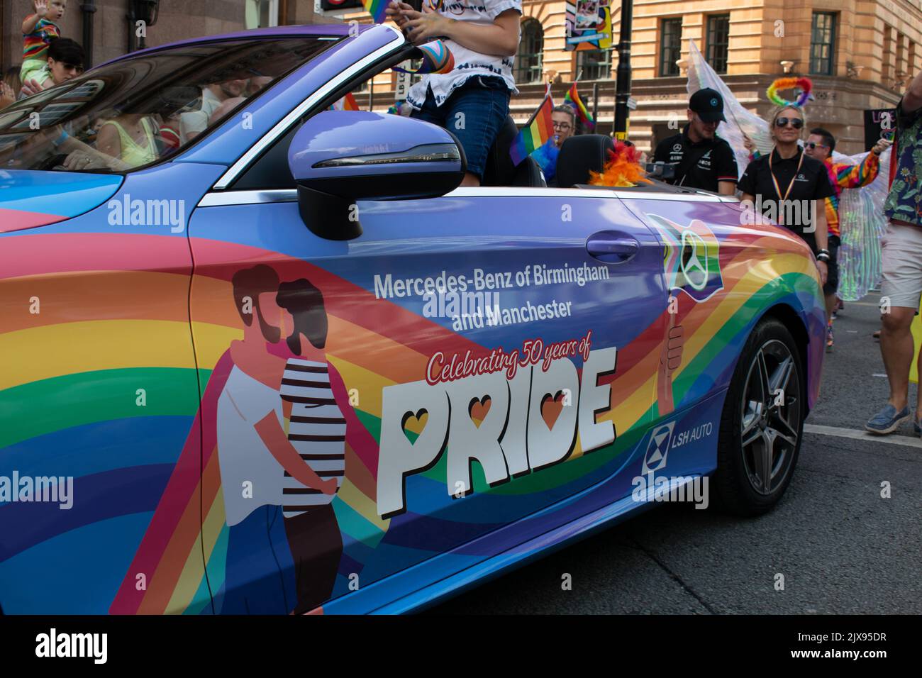 Manchester Pride parade. Mercedes Benz car painted with rainbow and text Celebrating 50 years of Pride. Theme March for Peace. Stock Photo