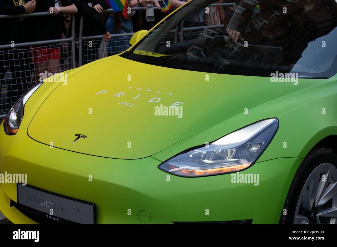 Manchester Pride parade. Tesla model 3 car in rainbow colours. Theme March for Peace. Stock Photo