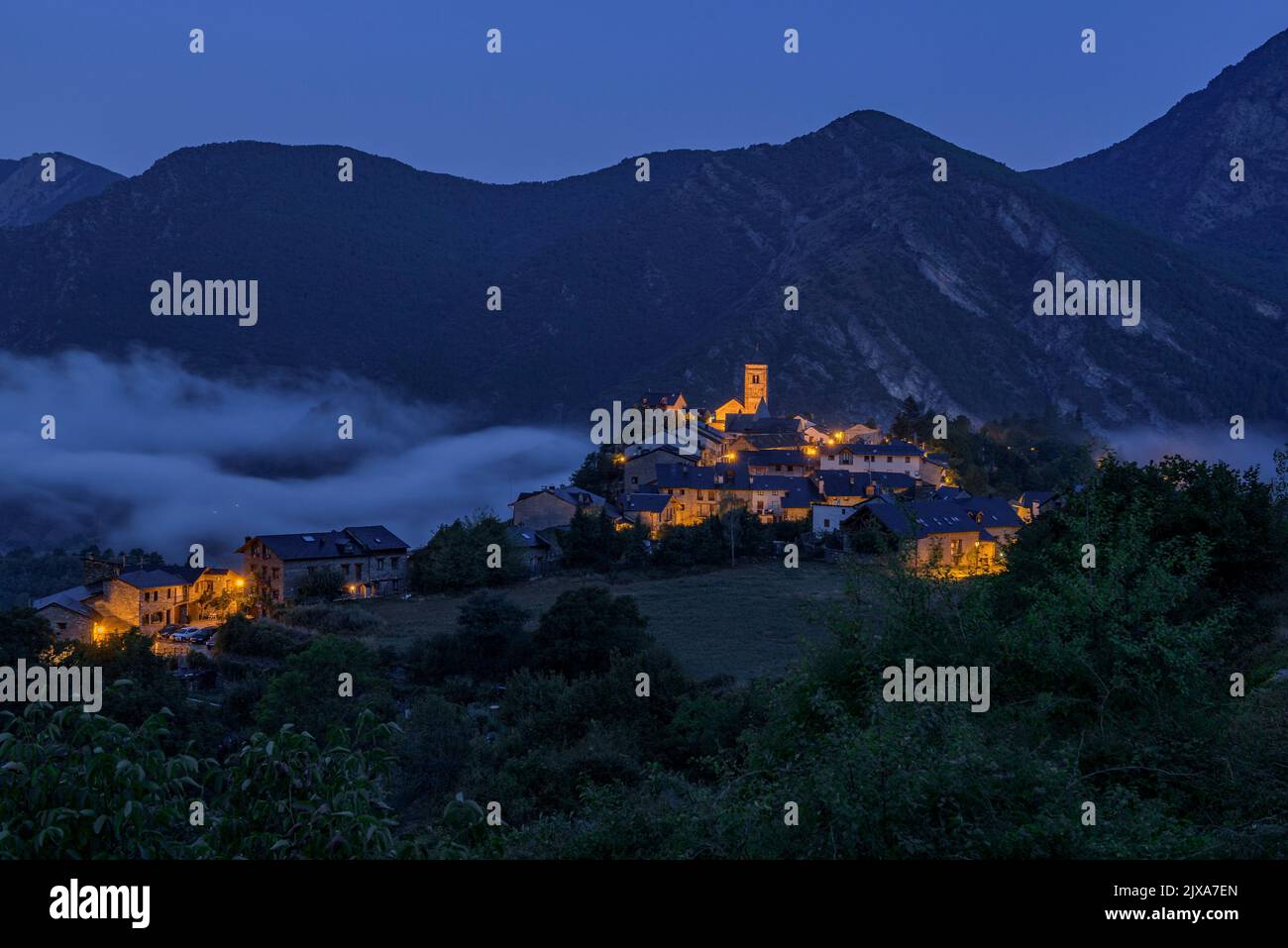 Tírvia village at blue hour with fog (Pallars Sobirà, Lleida, Catalonia, Spain, Pyrenees)  ESP: Pueblo de Tírvia en la hora azul con niebla (Lérida) Stock Photo