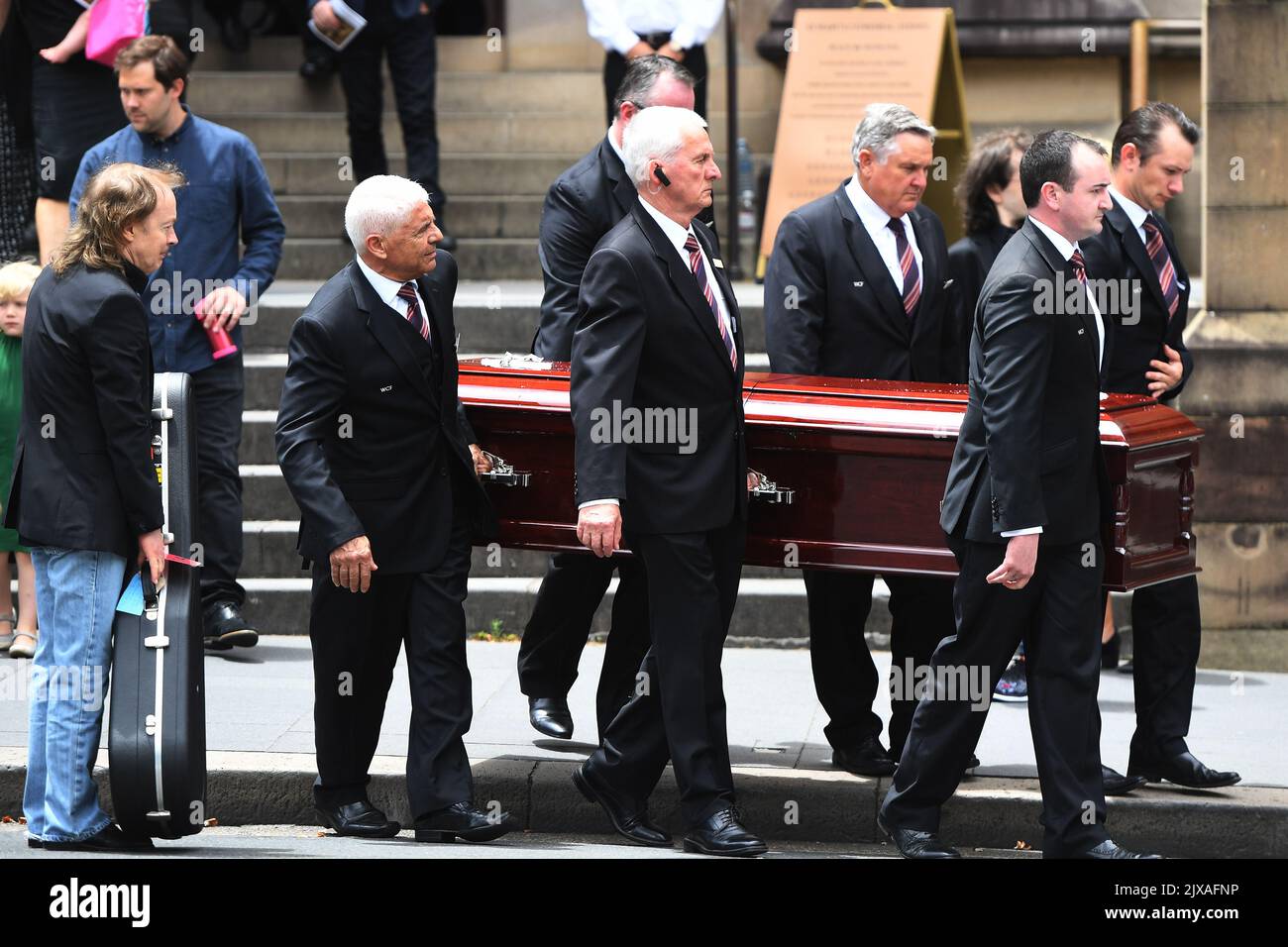 Angus Young (left) holds a guitar as the casket of his brother AC/DC co ...
