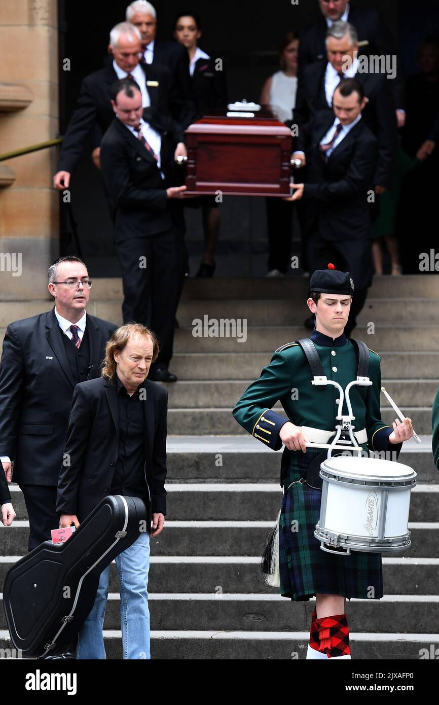 Angus Young (left) carries a guitar as he leads the casket of his ...