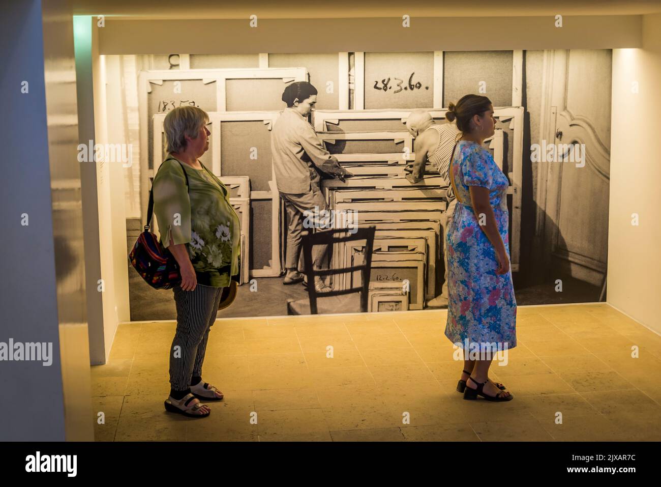 Web musée picasso paris is a museum in paris. Two women looking at a Picasso painting and a photograph of him and