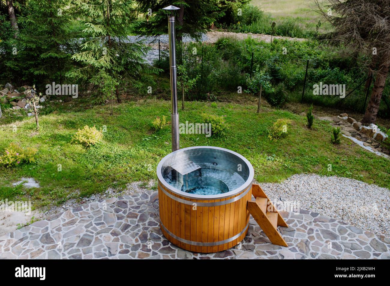 Wooden bathtub with a fireplace to burn wood and heat water in backyard