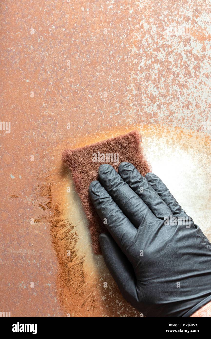 Rubbing rust off sheet steel with an abrasive pad. Restoration project