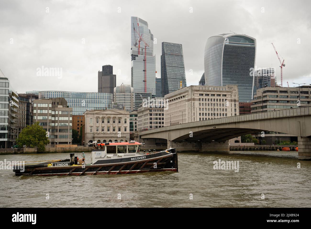 The City of London with a boat on the river Thames called 'Recovery' which has to be good news! Stock Photo