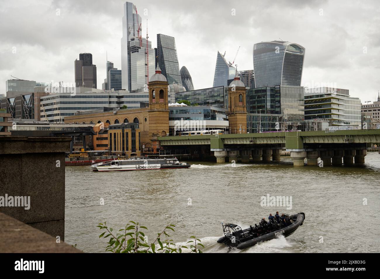 The City of London from Southwark Bridge with a Police rib in the foreground travelling at speed. Stock Photo
