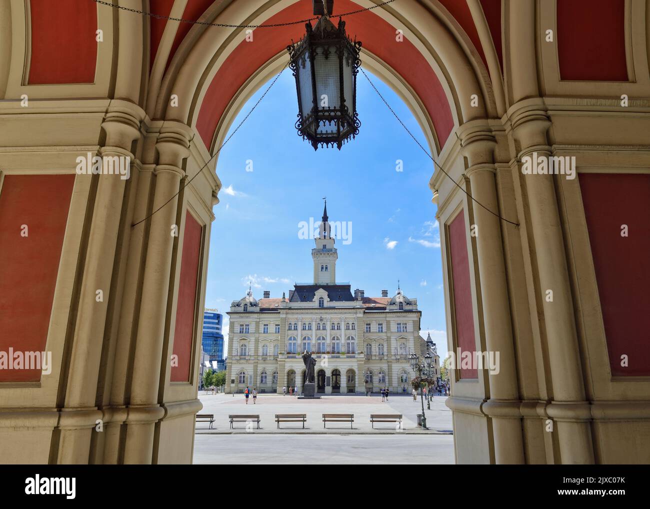 City Hall viewed from below the arches of the Name of Mary Church, Liberty Square, Novi Sad, Serbia Stock Photo