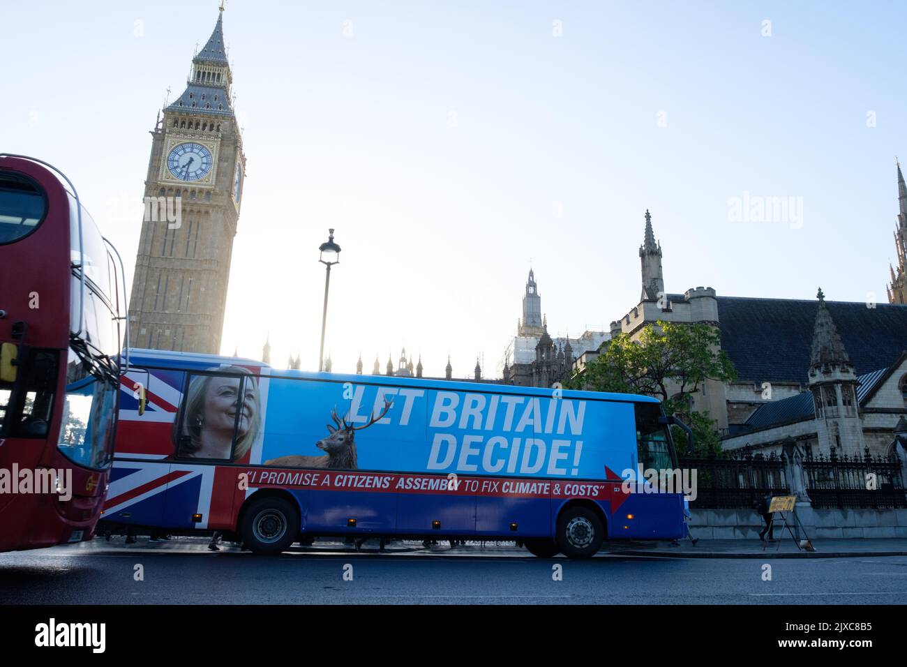 London, UK. 7 SEP, 2022.  A bus with Liz Truss face and a sign that reads “Let Britain Decide” and “I promise a citizens’ assembly to fix climate & costs” drives past the Houses of Parliament and around parliament square the morning that Britain wakes up with Liz Truss as first Prime Minister’s Questions after she was announced as the new Conservative party leader, and appointed as Prime Minister, replacing Boris Johnson. Credit: Joao Daniel Pereira Credit: Joao Daniel Pereira/Alamy Live News Stock Photo