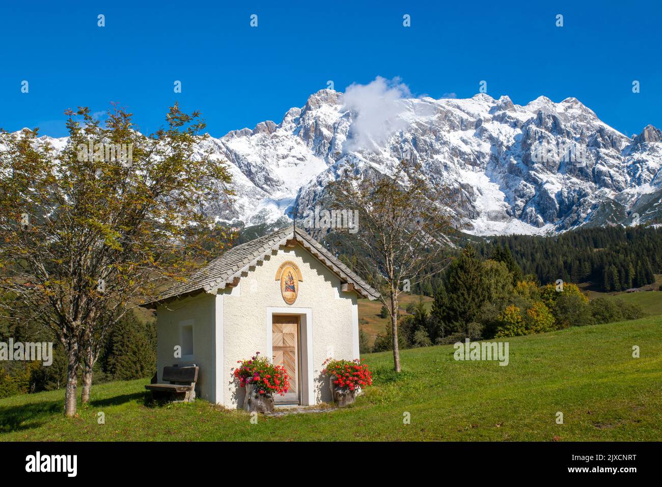 Chapel in autumn with the snow-covered Hochkoenig mountain (2.943m) in background. Pinzgau region, Salzburgerland, Austria Stock Photo