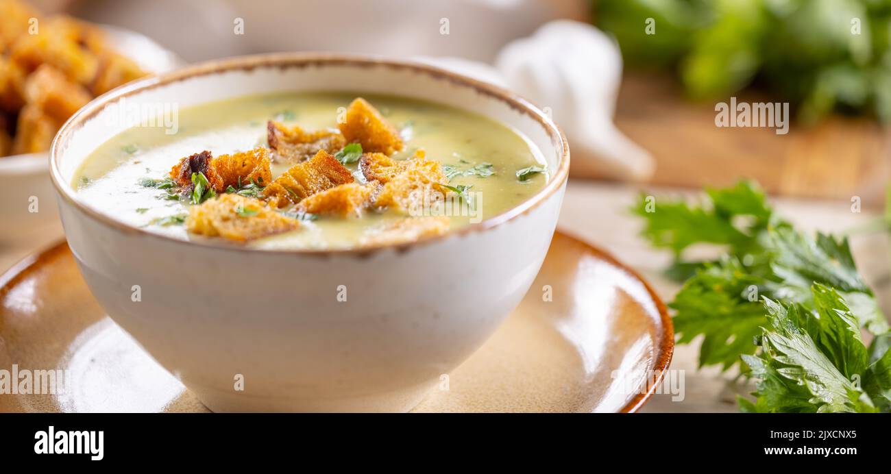 Garlic cream soup with bread croutons in rustic bowl. Stock Photo