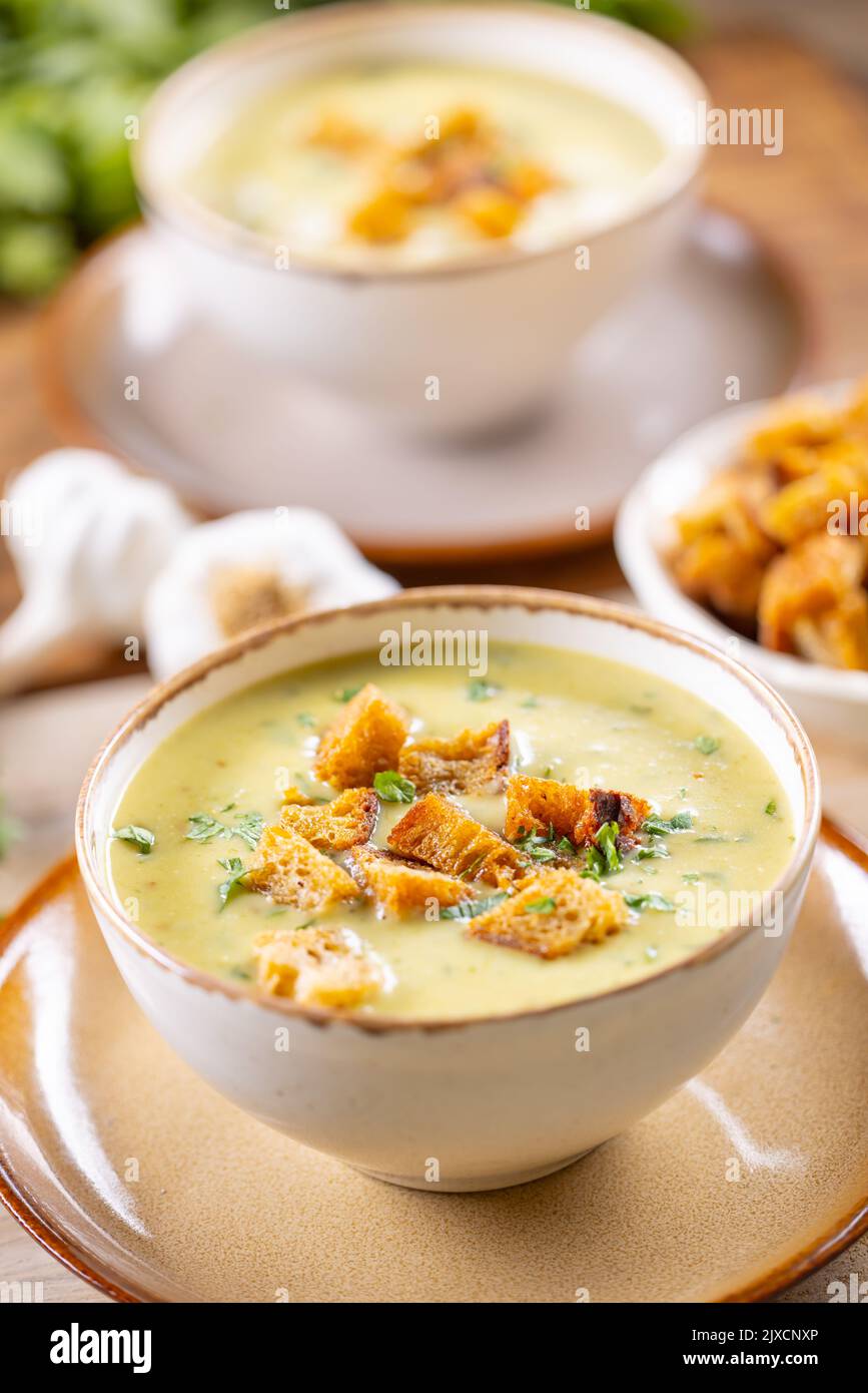 Garlic cream soup with bread croutons in rustic bowl. Stock Photo