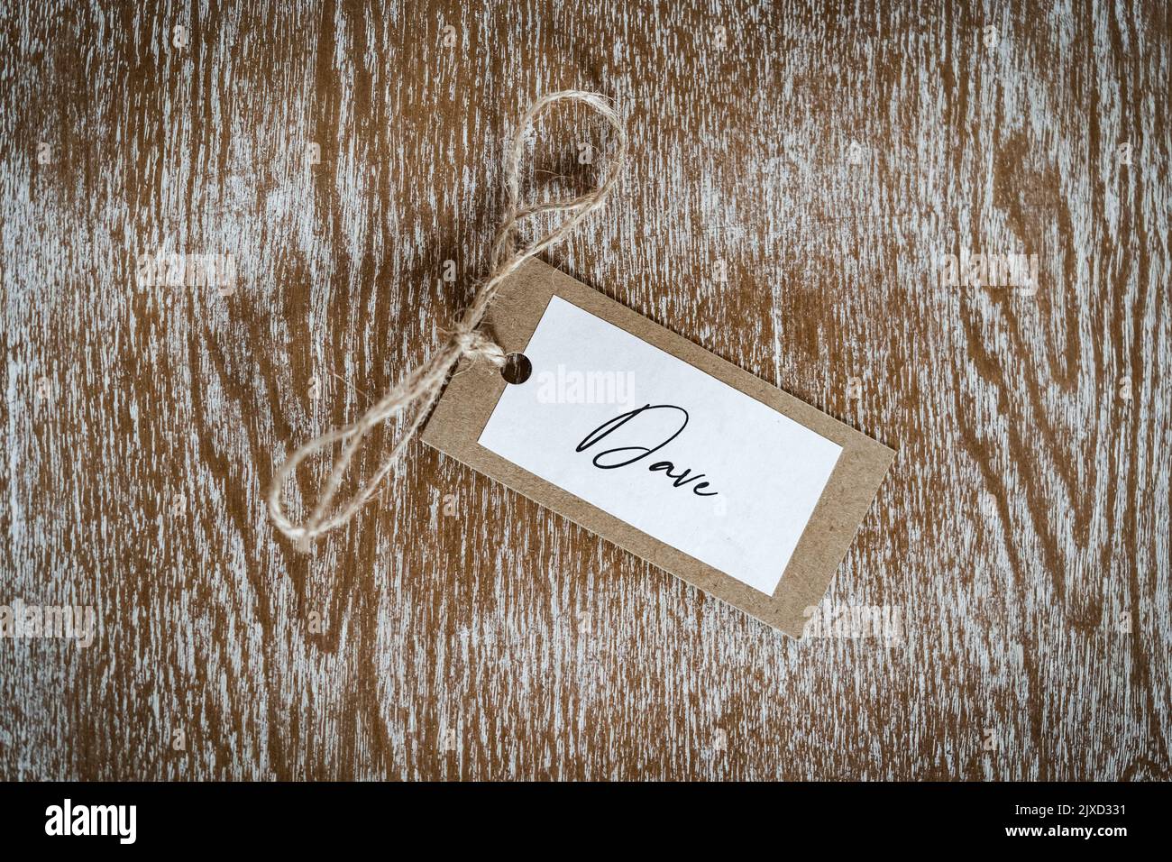 Personalised name Dave place card with string label beautiful crafted placard.  Laid on solid oak wooden table named ticket. Stock Photo