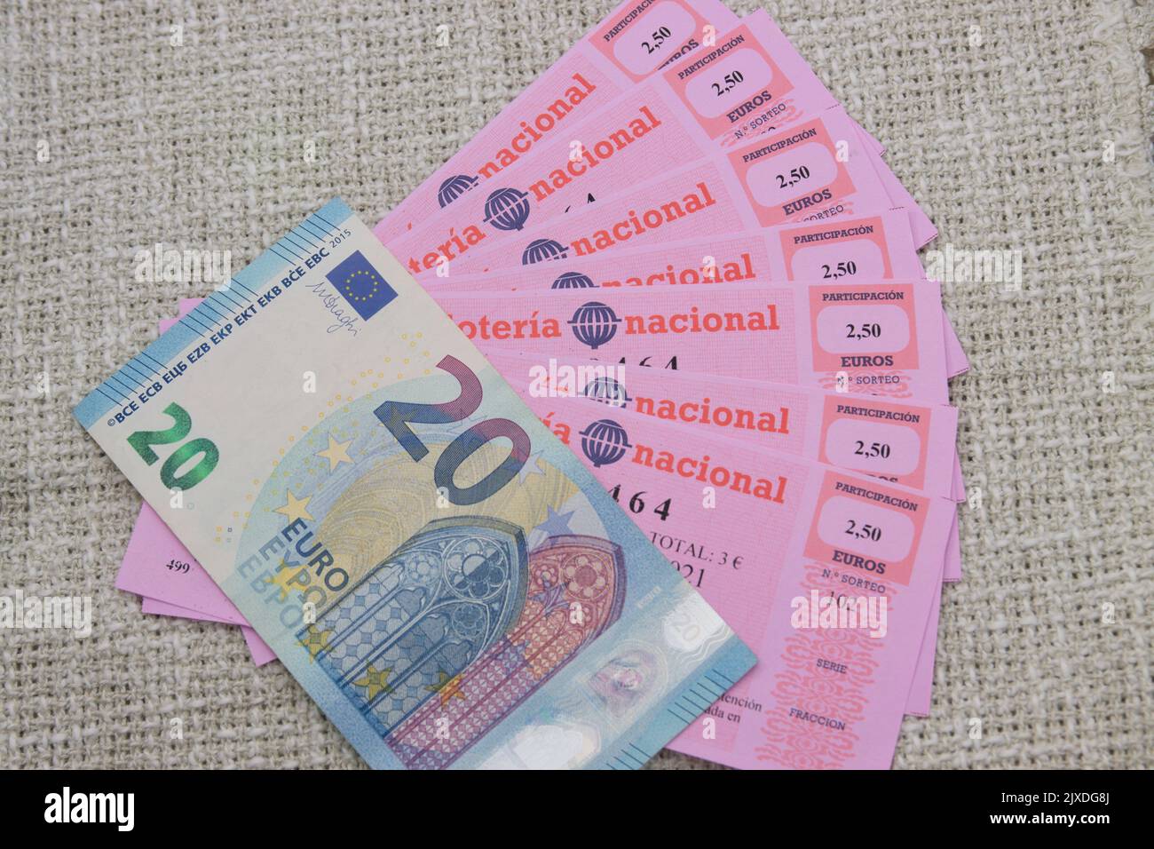 Participations equivalent to a Spanish national lottery ticket worth €20 together with a €20 bill on a neutral background Stock Photo