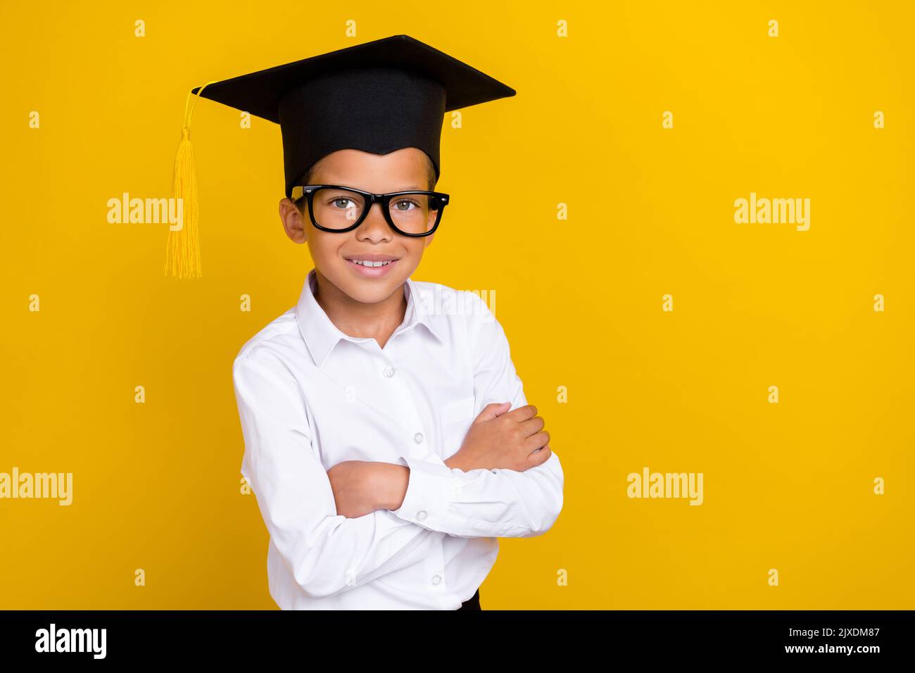 Portrait of positive smart boy folded arms beaming smile empty space ...