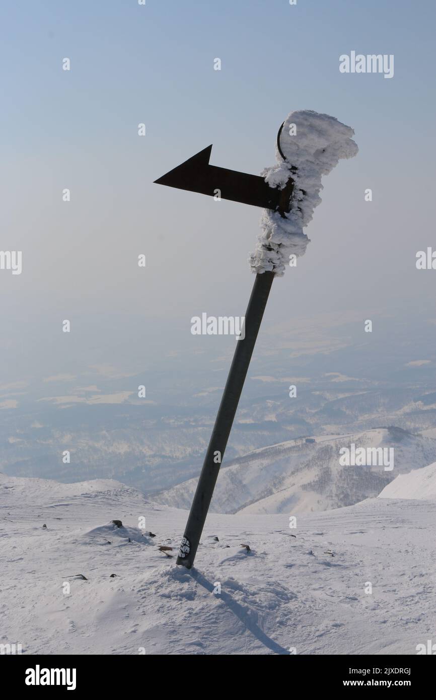 Frozen metal signpost on mountain summit Stock Photo