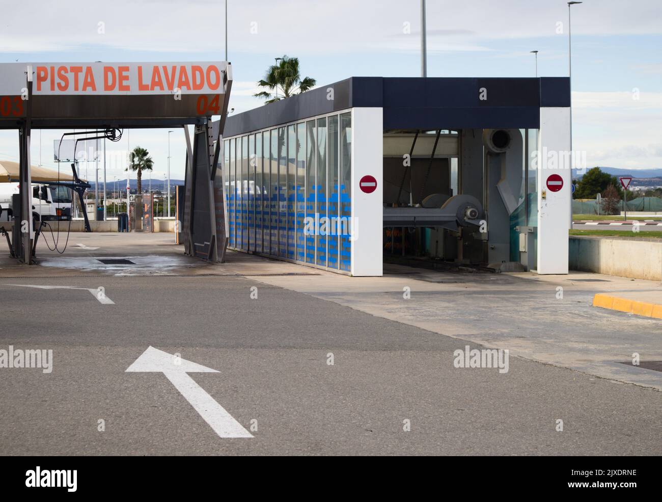 Image of a car wash lane next to a robot that cleans cars from the outside automatically at a Spanish gas station Stock Photo