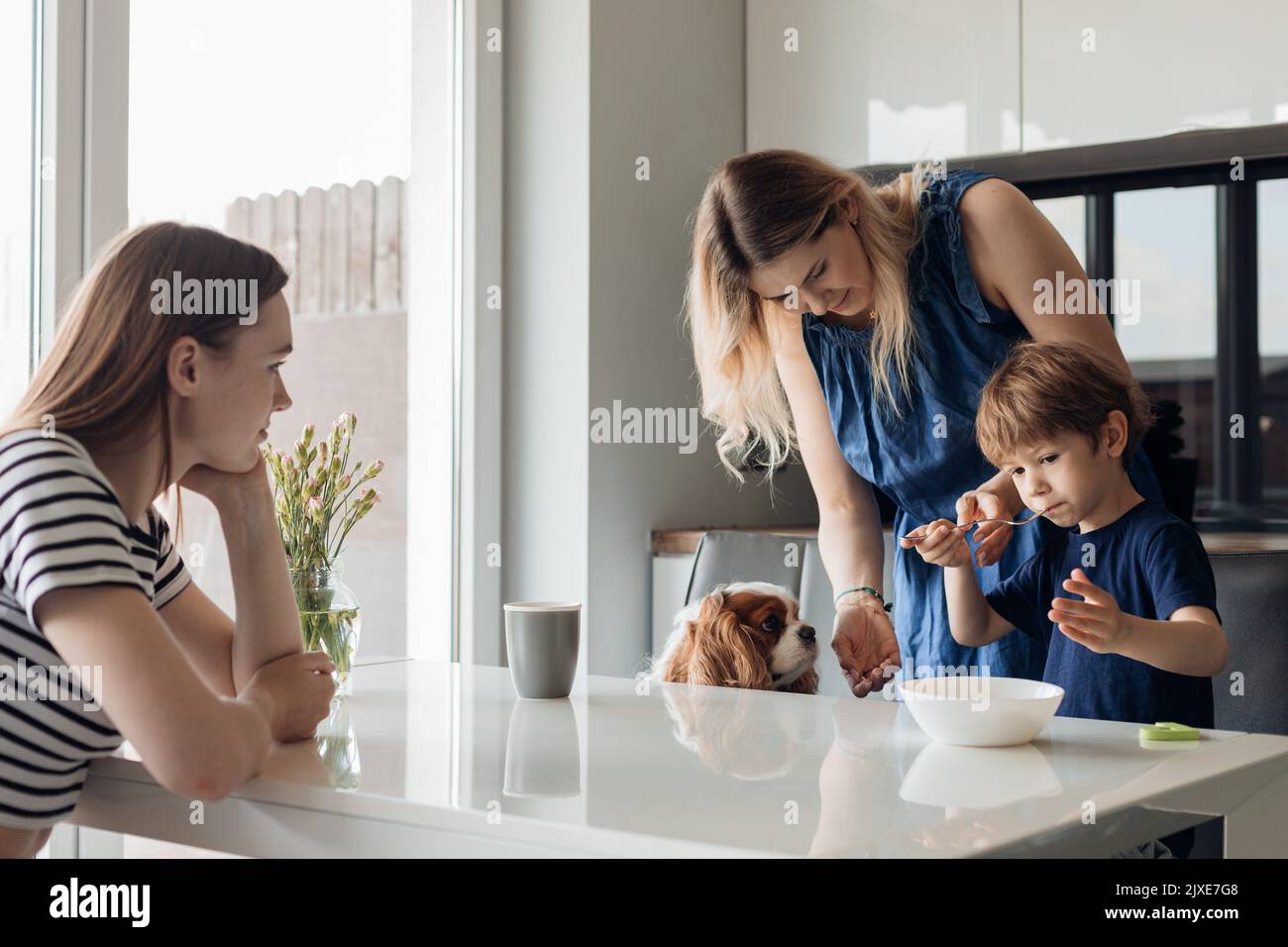 Two calm and disappointed women and little sad boy, refusing food sit