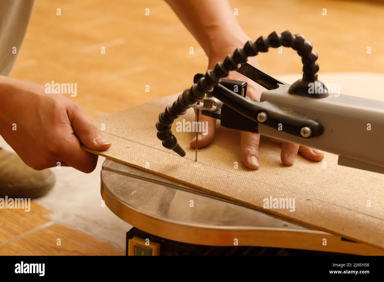 Carpenter's hands are working on scroll saw Stock Photo