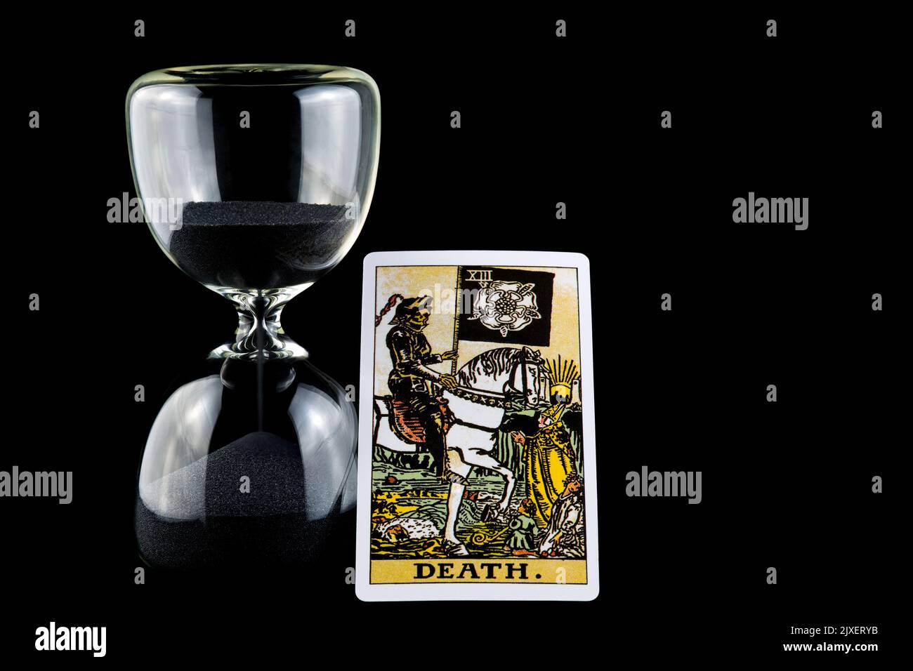 Death tarot card and hourglass isolated against a black background Stock Photo
