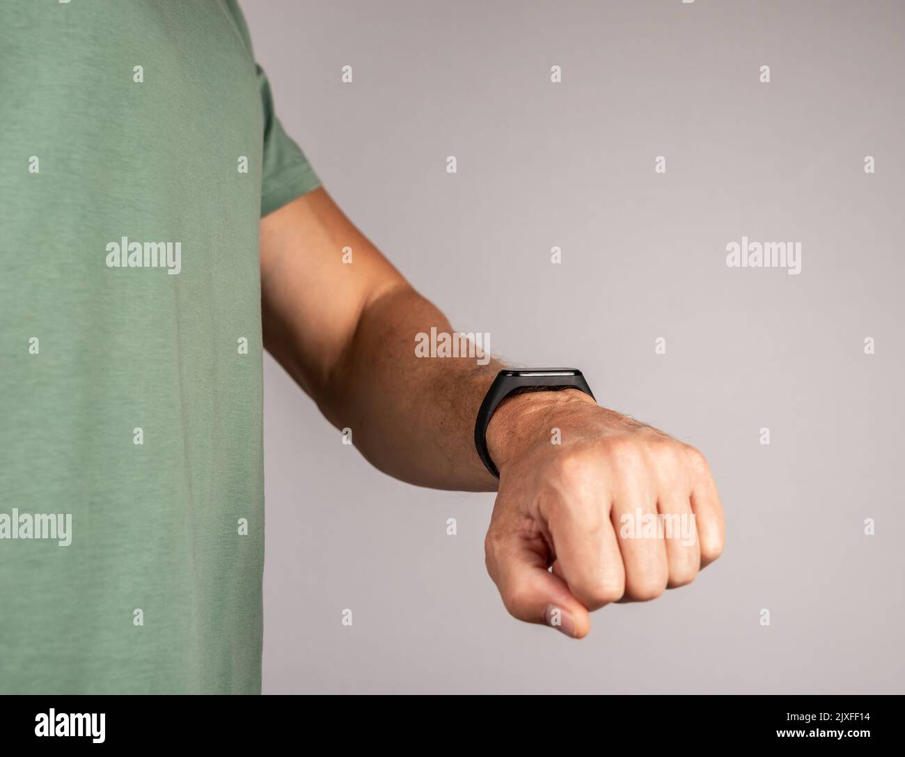 Man looking at fitness bracelet for walking steps, running distance or heart rate monitoring. Physical well-being improvement. Healthy lifestyle conce Stock Photo