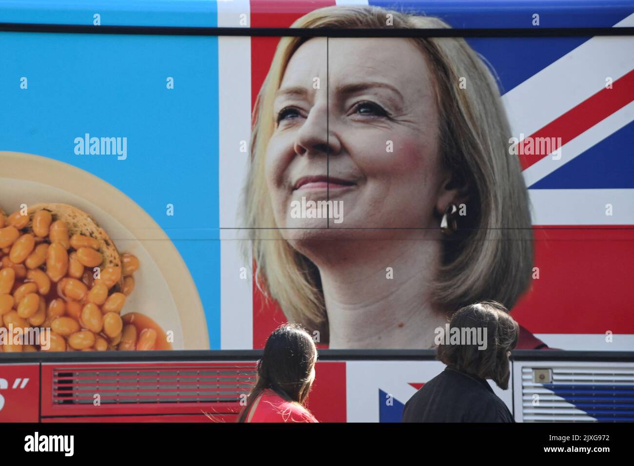 People walk past an image of new British Prime Minister Liz Truss on the side of a protest bus calling for a citizens assembly, parked in central London, Britain September 7, 2022. REUTERS/Toby Melville Stock Photo