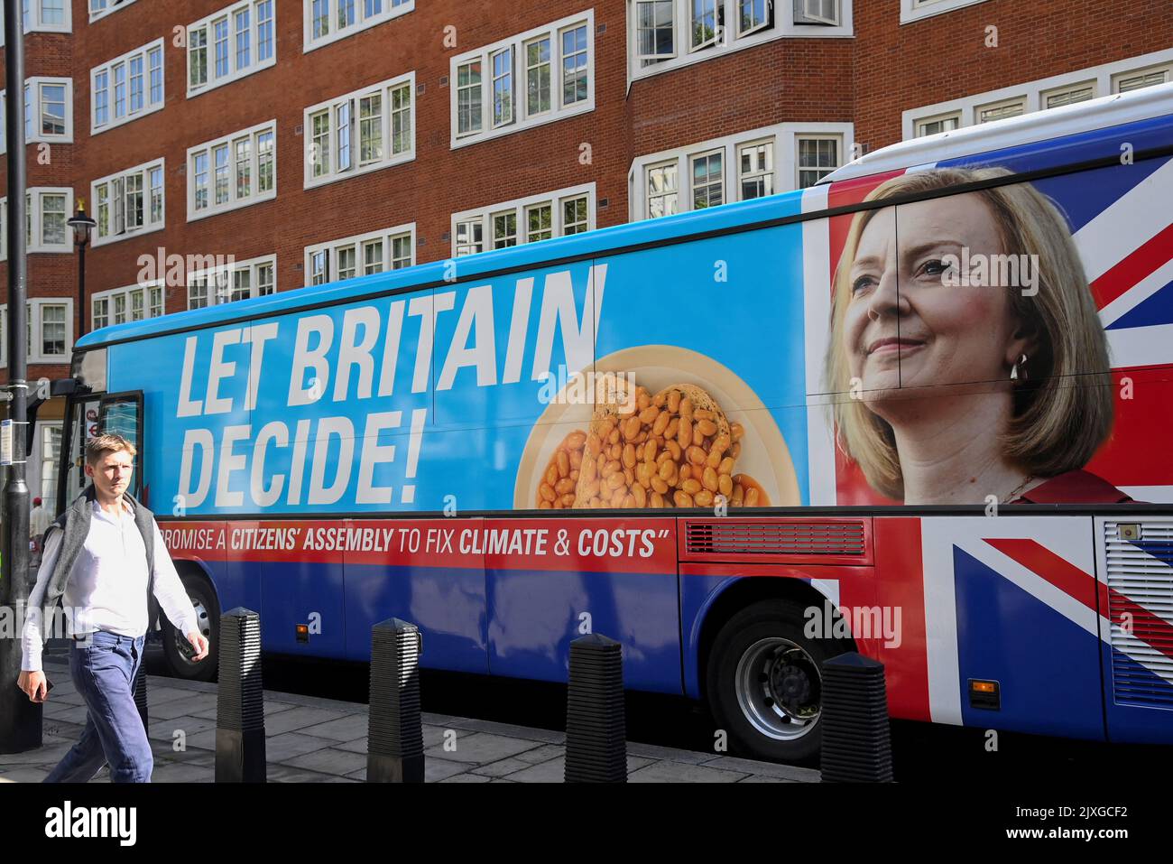 A man walks past an image of new British Prime Minister Liz Truss on the side of a protest bus calling for a citizens assembly, parked in central London, Britain September 7, 2022. REUTERS/Toby Melville Stock Photo