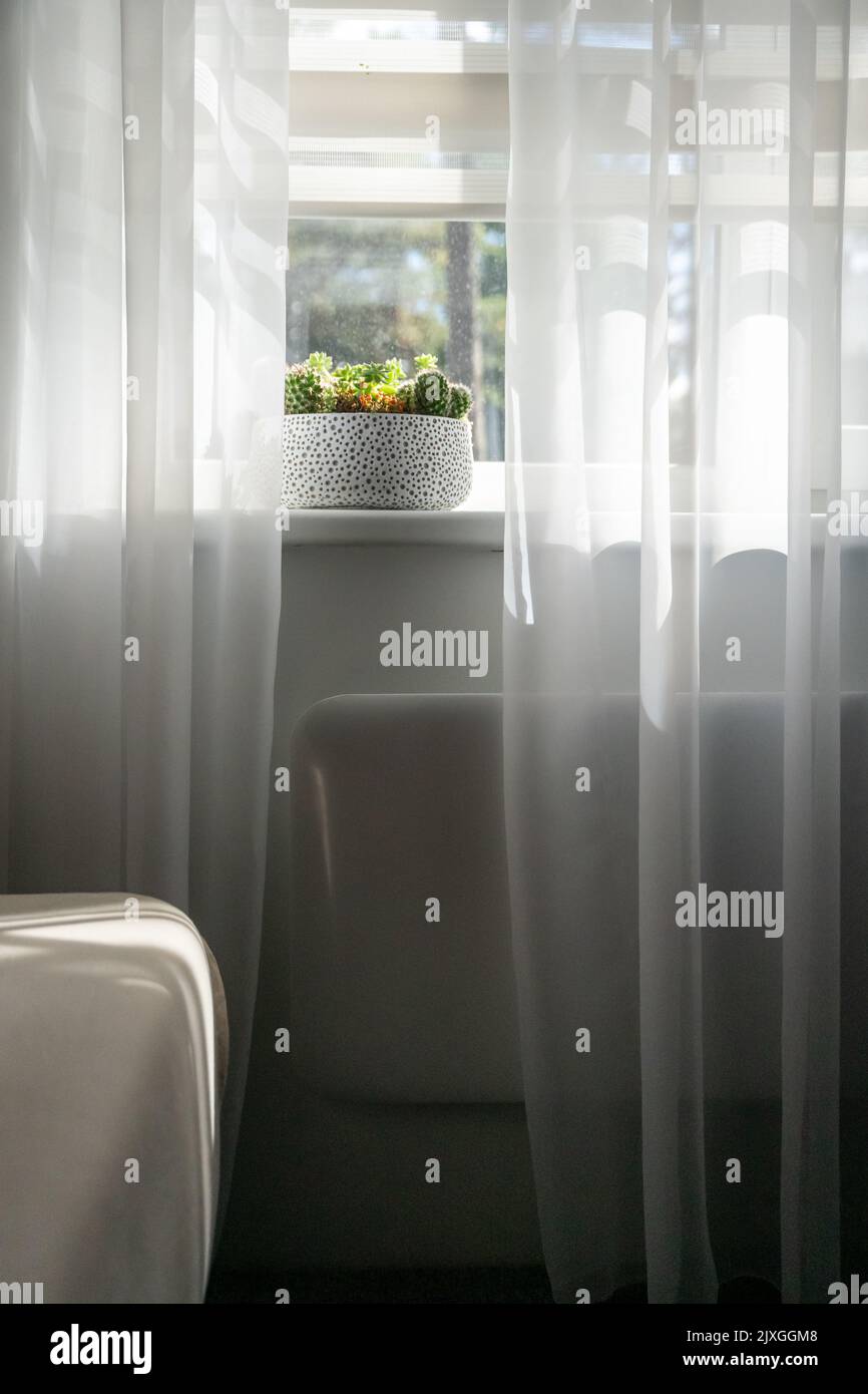 Electric heating radiator under window with curtains in living room ...