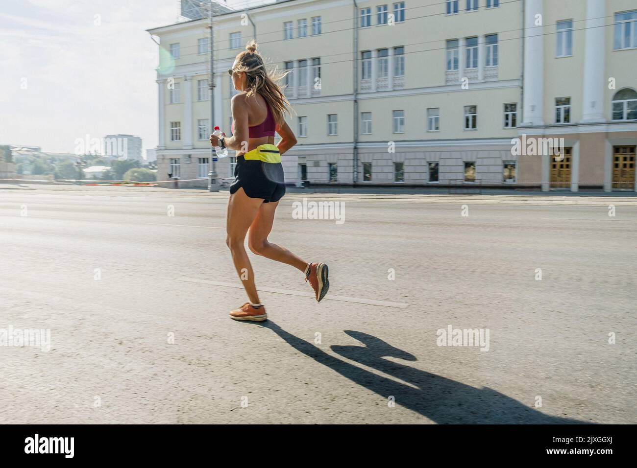 female runner running in morning on city street Stock Photo