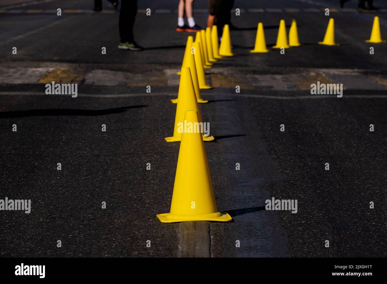 yellow traffic cones on dark asphalt indicating turn Stock Photo Alamy
