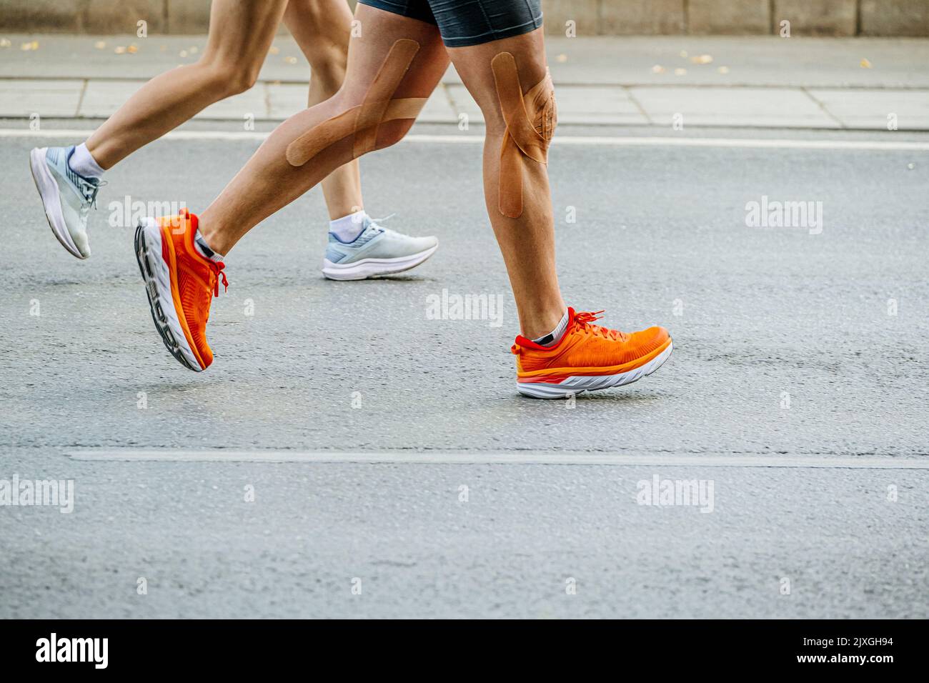 legs runners man and woman run on road marathon Stock Photo