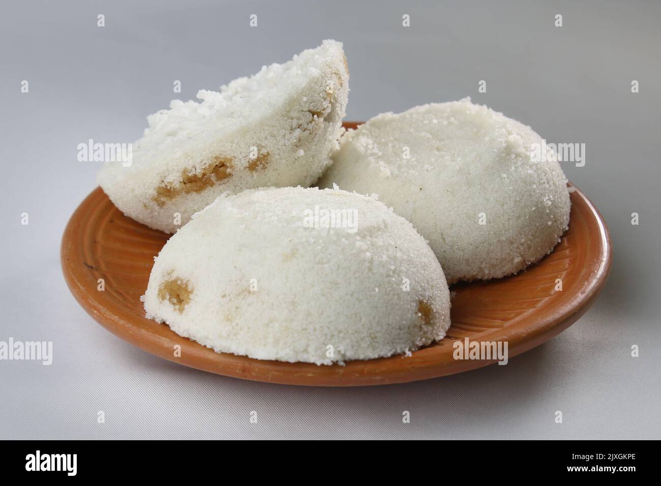 Steamed Rice Cake or Bhapa Pitha is a traditional dish of Bangladesh. Winter Vapa Pitha snacks on clay plate. Stock Photo