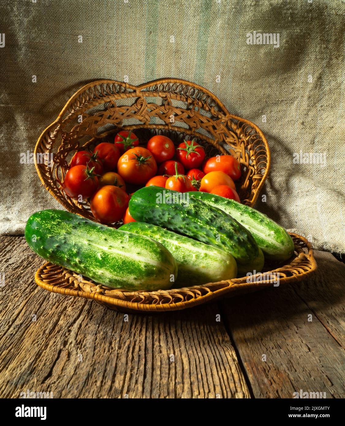 Vegetables on the background of burlap close-up. Food in the basket. Summer harvest on the table Stock Photo
