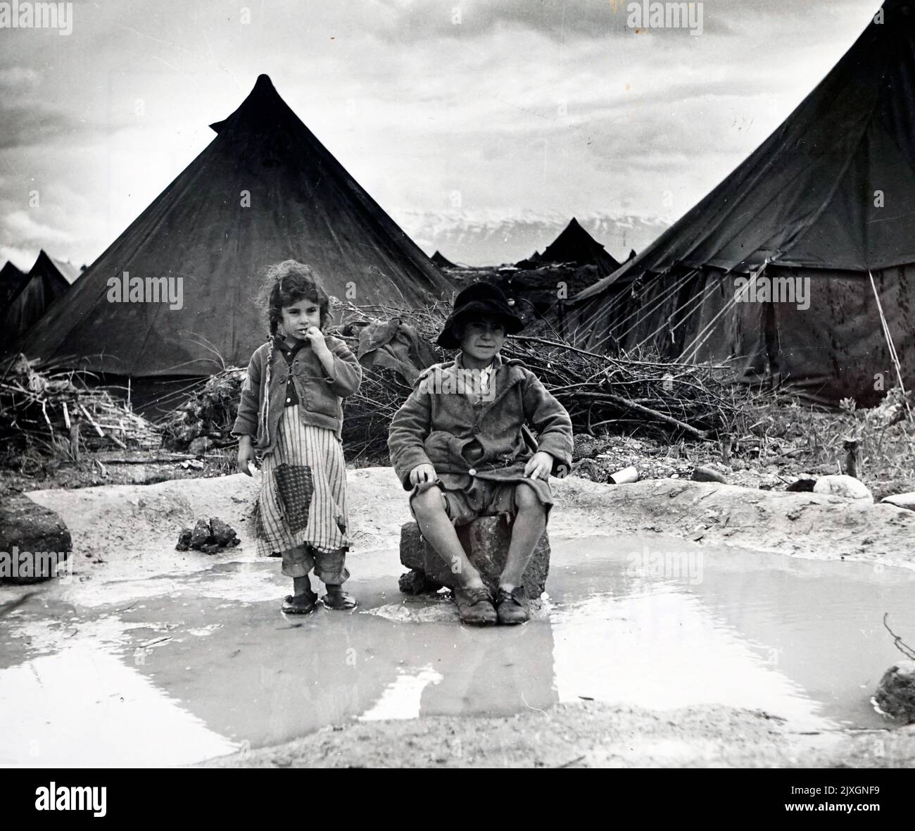 Photograph shows two children watching over their family tents after nearly all of their possessions have been washed away during the floods in Tripoli, Lebanon. Dated 20th Century Stock Photo