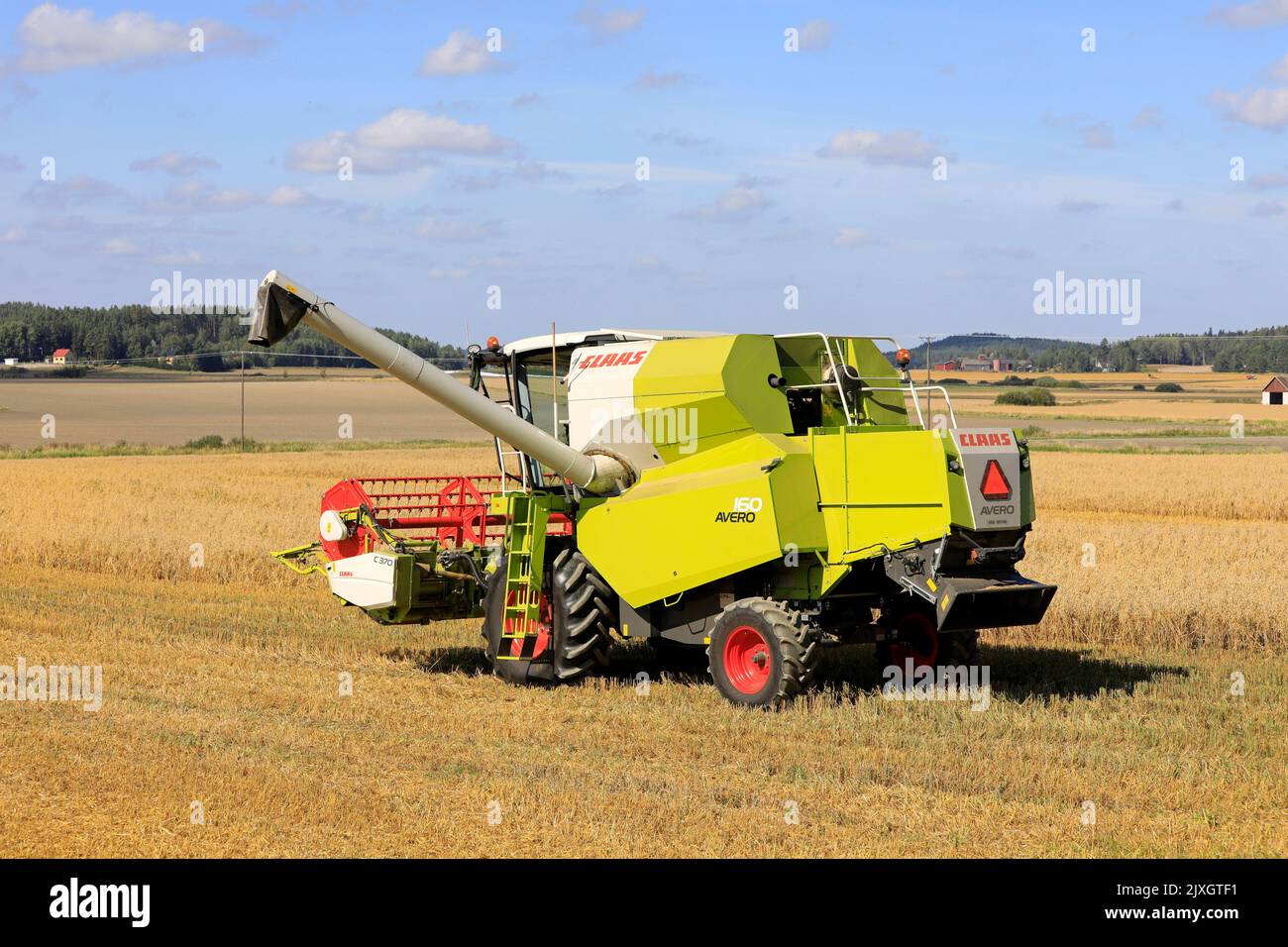 Claas Avero 160 combine harvester in partially harvested ripe oat field on a sunny day of August. Salo, Finland. August 27, 2022. Stock Photo