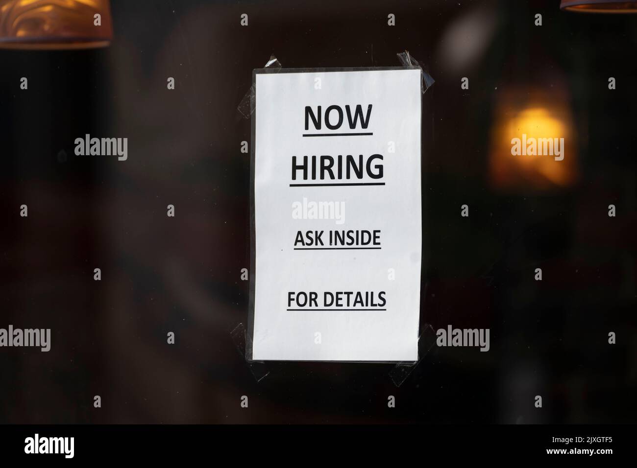 A sign in the window of a small business which says Ònow hiring ask inside for detailsÓ in Cardiff, United Kingdom. Stock Photo
