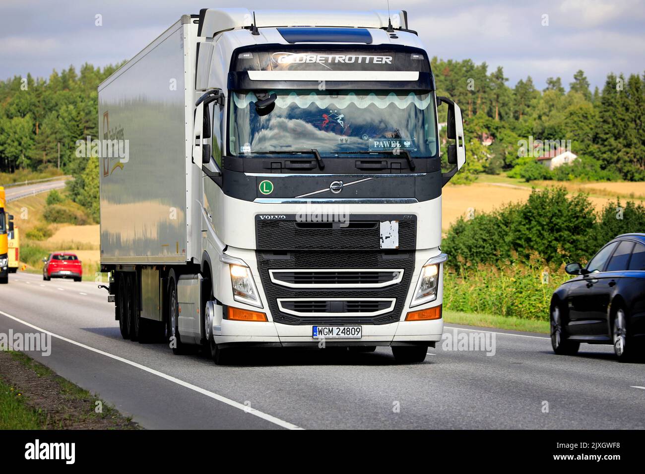 White Volvo FH truck Globetrotter cab pulls semi trailer in highway traffic on a day of late summer. Salo, Finland. August 25, 2022. Stock Photo