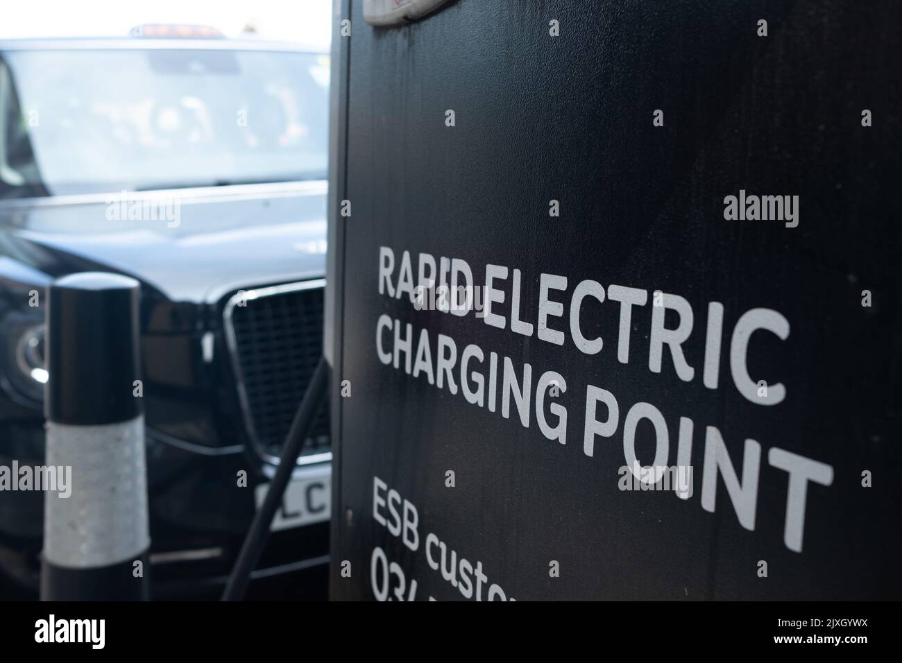 London- August 2022: London electric taxi at a Rapid Electric Charging Point off Streatham High Road in south west London Stock Photo