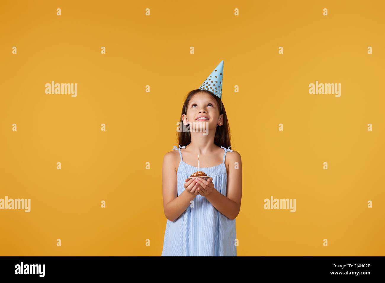 happy little girl with party cone making wish Stock Photo Alamy
