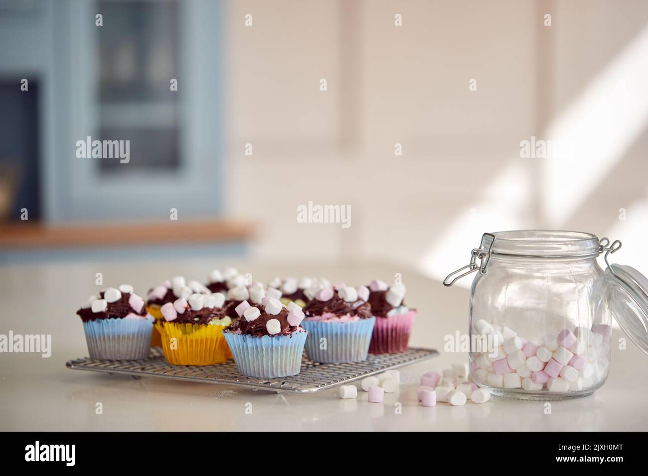 Close Up Of Marshmallows And Decorated Cupcakes On Cooling Rack In Kitchen Stock Photo