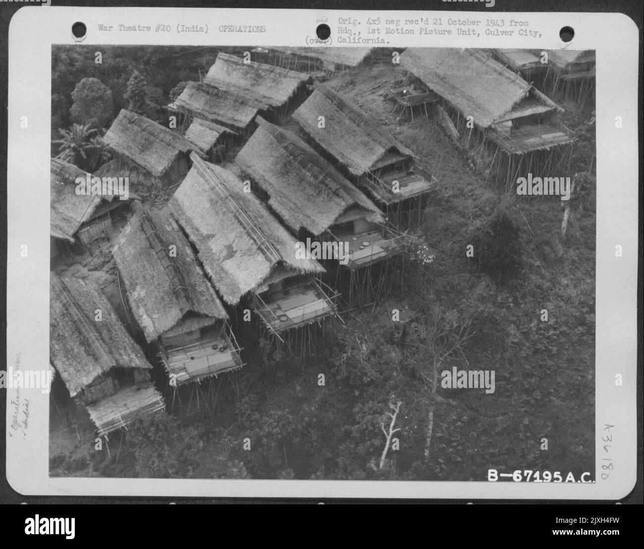 A Naga Village Was Nestles In The Burmese Jungles. Because Of The Necessity Of Being On The Alert Constantly Against Fellow Headhunters, The Nagas Built Their Houses High Off Hte Ground; The Door Is Reached By A Ladder Which Is Withdrawn At Night - The R Stock Photo