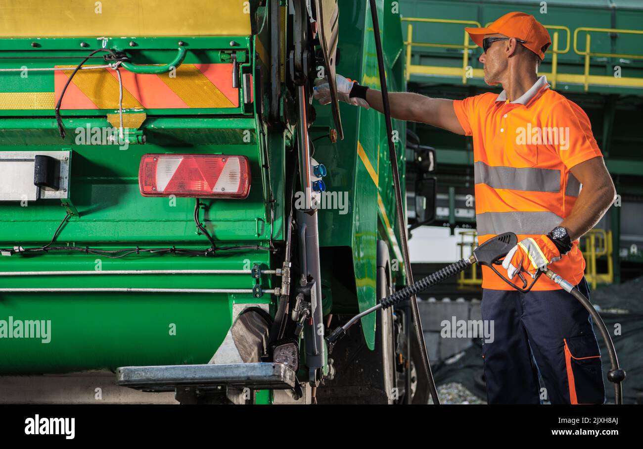 garbage-truck-worker-with-pressure-washer-lance-in-his-hands-staying