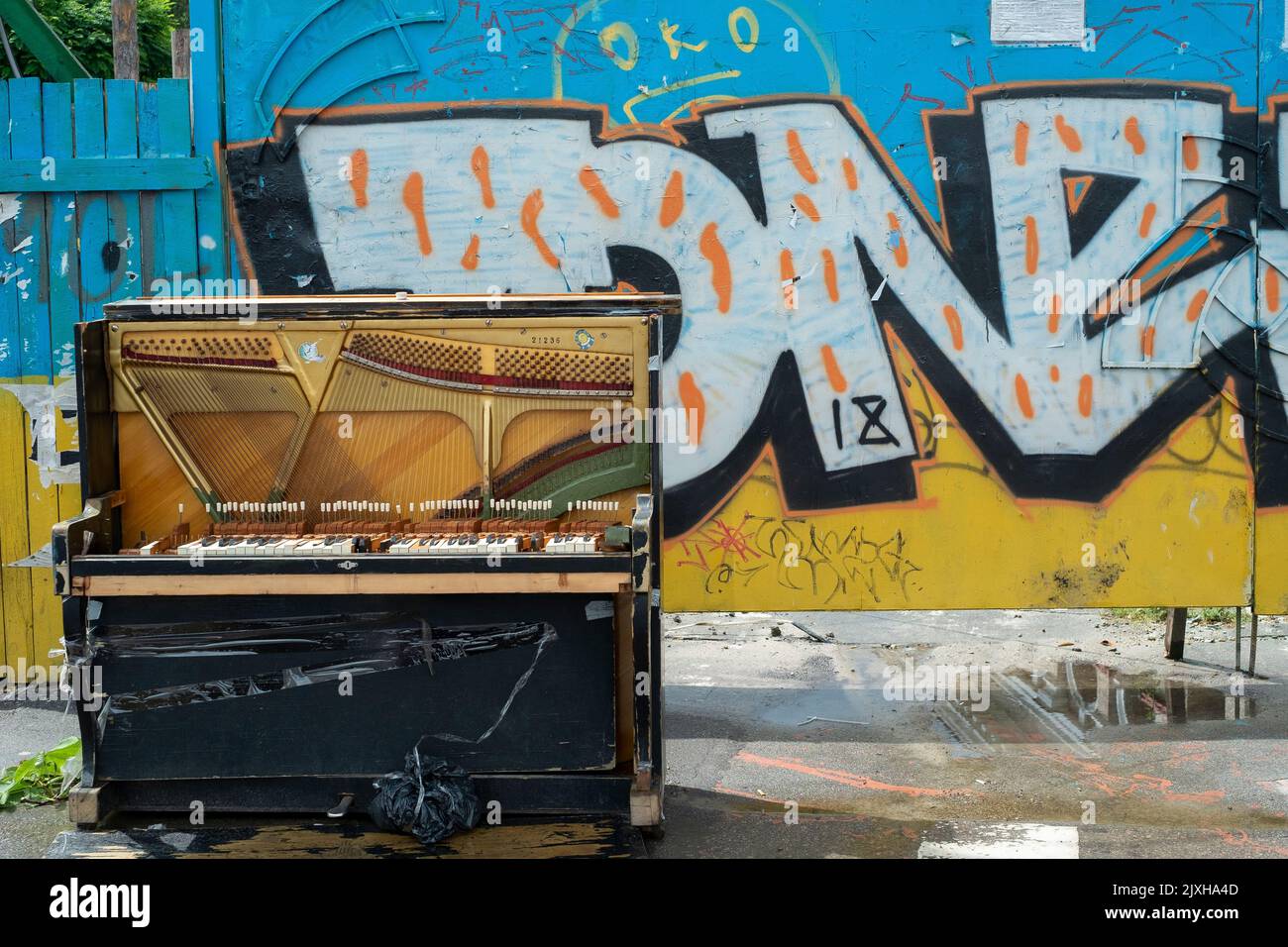 Colorful piano in the street with graffiti background Stock Photo