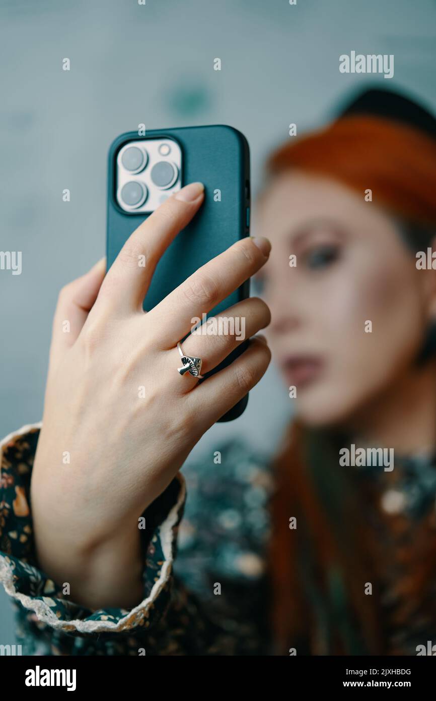Attractive woman posing takes selfie on iPhone 13 pro. Stock Photo