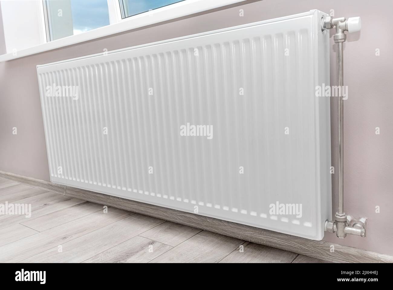 Modern radiator under the window. Stock Photo