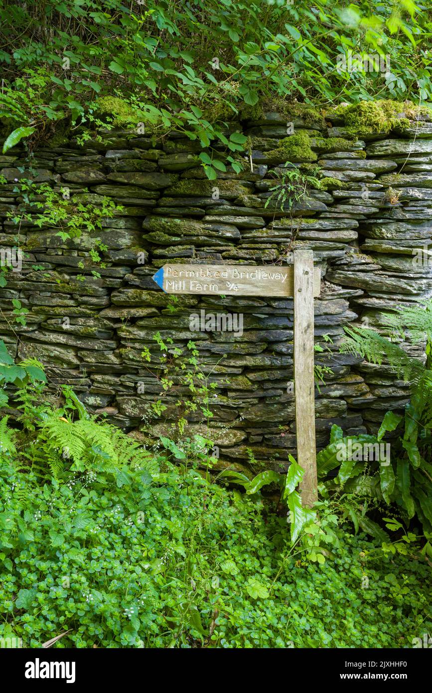 A wooden signpost for the Bridleway through Invention Wood to Mill Farm in the Heddon Valley in the Exmoor National Park, North Devon, England. Stock Photo