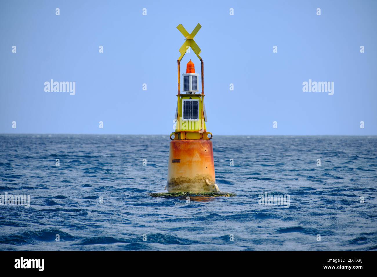 yellow channel marker buoy floating in the sea lighthouse nautical