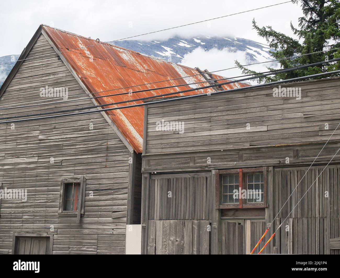 Old weatherboard building, unpainted and weathered with rusty ...
