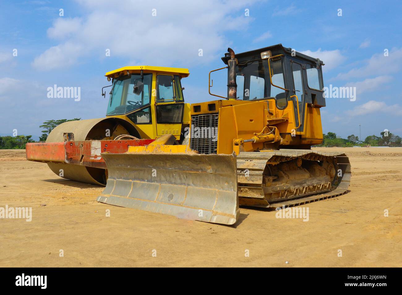 bulldozer and road roller with yellow color, on construction site and sky background Stock Photo